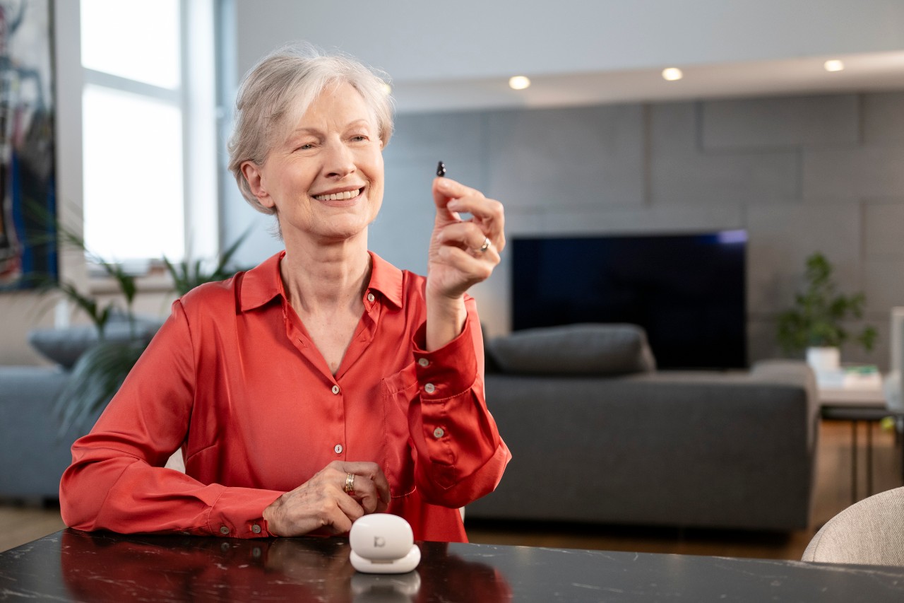 Senior woman with hearing aid in comfortable home setting